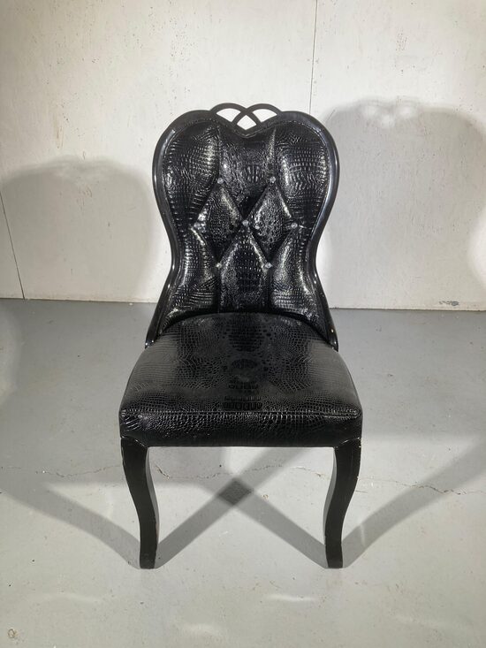 Melni krēsli ar kristāla kniedēm.