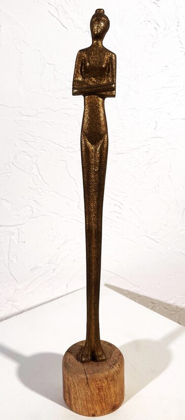 Zelta figūra uz koka statīva